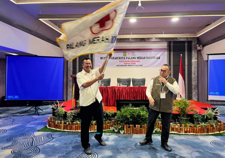 H Aftahuddin mengibarkan bendera PMI Kota Banjarmasin setelah resmi terpilih sebagai Ketua PMI Kota Banjarmasin yang disaksikan Ketua Bidang Organisasi PMI Pusat, Sudirman Said