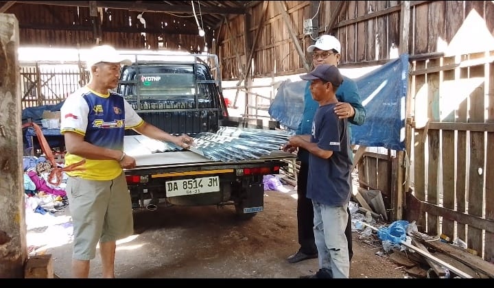 Anggota DPRD Banjarmasin Zainal Hakim saat menyerahkan bantuan bahan bangunan kepada perwakilan warga.