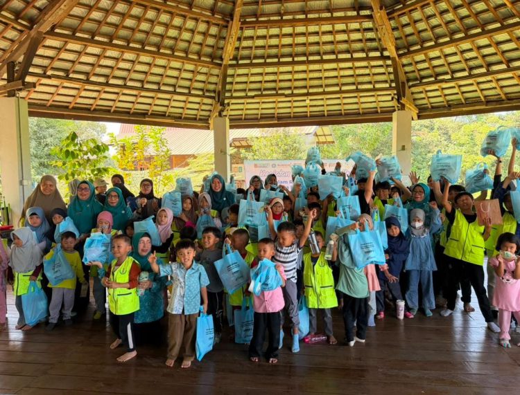 Sejumlah siswa berfoto bersama sambil menunjukkan paket bantuan yang diterima usai kegiatan GEMARIKAN di Sekolah Alam Tanjung, Kabupaten Tabalong.