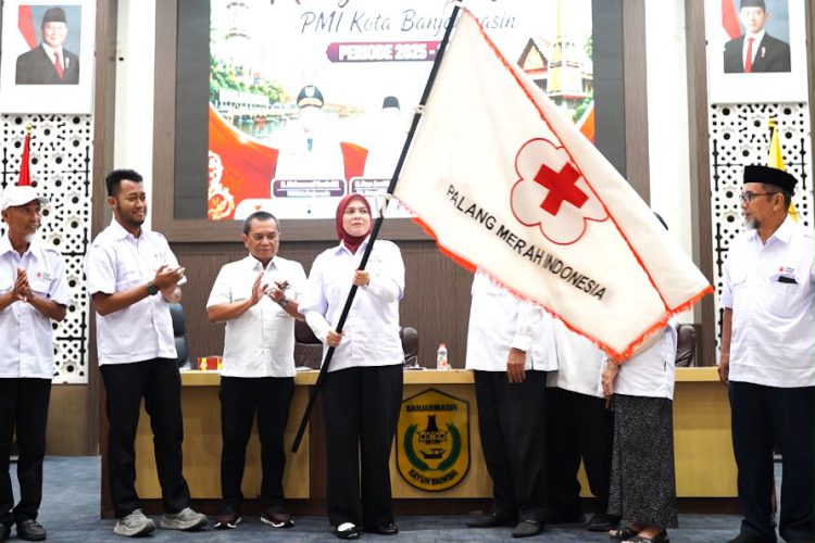 Ananda mengibarkan bendera PMI usai ditetapkan secara aklamasi sebagai ketua PMI Kota Banjarmasin