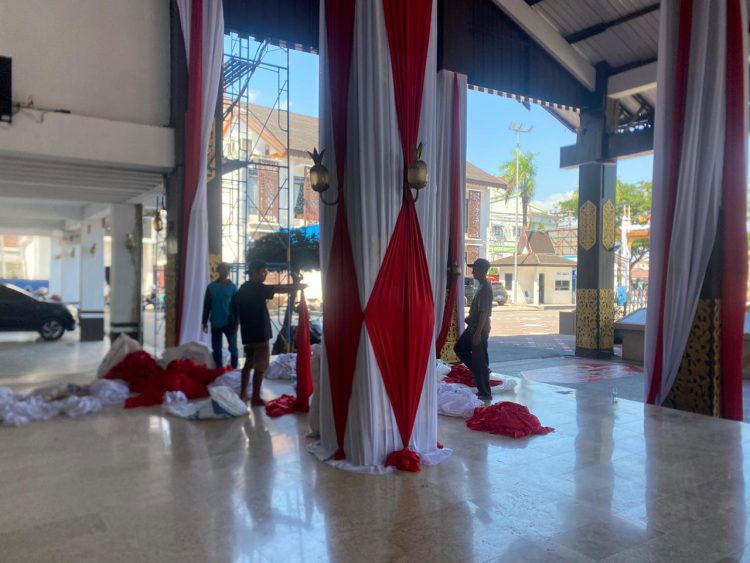 Sejumlah pekerja sedang memasang kain bernuansa merah putih untuk menghiasi balai kota Banjarmasin