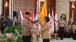 Gubernur H. Muhidin menyerahkan bendera kontingen kepada Ketua Kwartir Daerah Gerakan Pramuka Kalsel, Hj. Fathul Jannah Muhidin saat melepas peserta Jambore Nasional XII Tahun 2026.