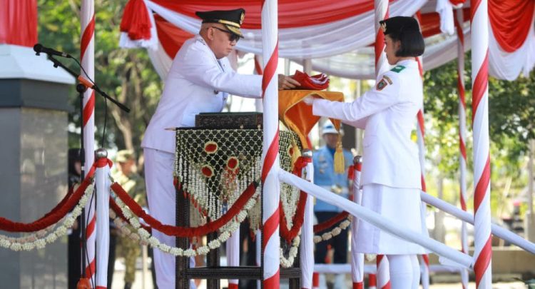 Gubernur Kalsel H. Muhidin menyerahkan bendera Merah Putih kepada anggota Paskibraka dalam Upacara HUT ke-81 Kemerdekaan RI.