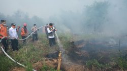 Gubernur Kalsel H. Muhidin menyemprotkan air ke titik api saat meninjau kebakaran hutan dan lahan di kawasan Guntung Damar, Ring 1 Bandara Internasional Syamsudin Noor, Banjarbaru.