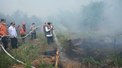 Gubernur Kalsel H. Muhidin menyemprotkan air ke titik api saat meninjau kebakaran hutan dan lahan di kawasan Guntung Damar, Ring 1 Bandara Internasional Syamsudin Noor, Banjarbaru.