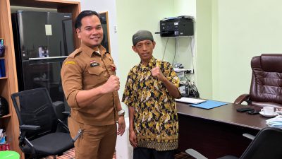 Plt Kabag Umum Setdako Banjarmasin, saat berfoto bersama dengan salah seorang tuna rungu penerima bantuan
